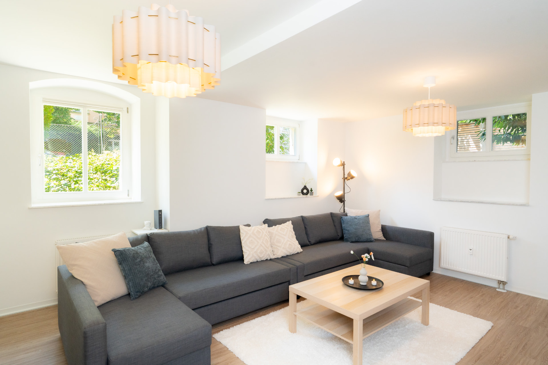 Großes graues Ecksofa mit Couchtisch in einem hellen Wohnzimmer